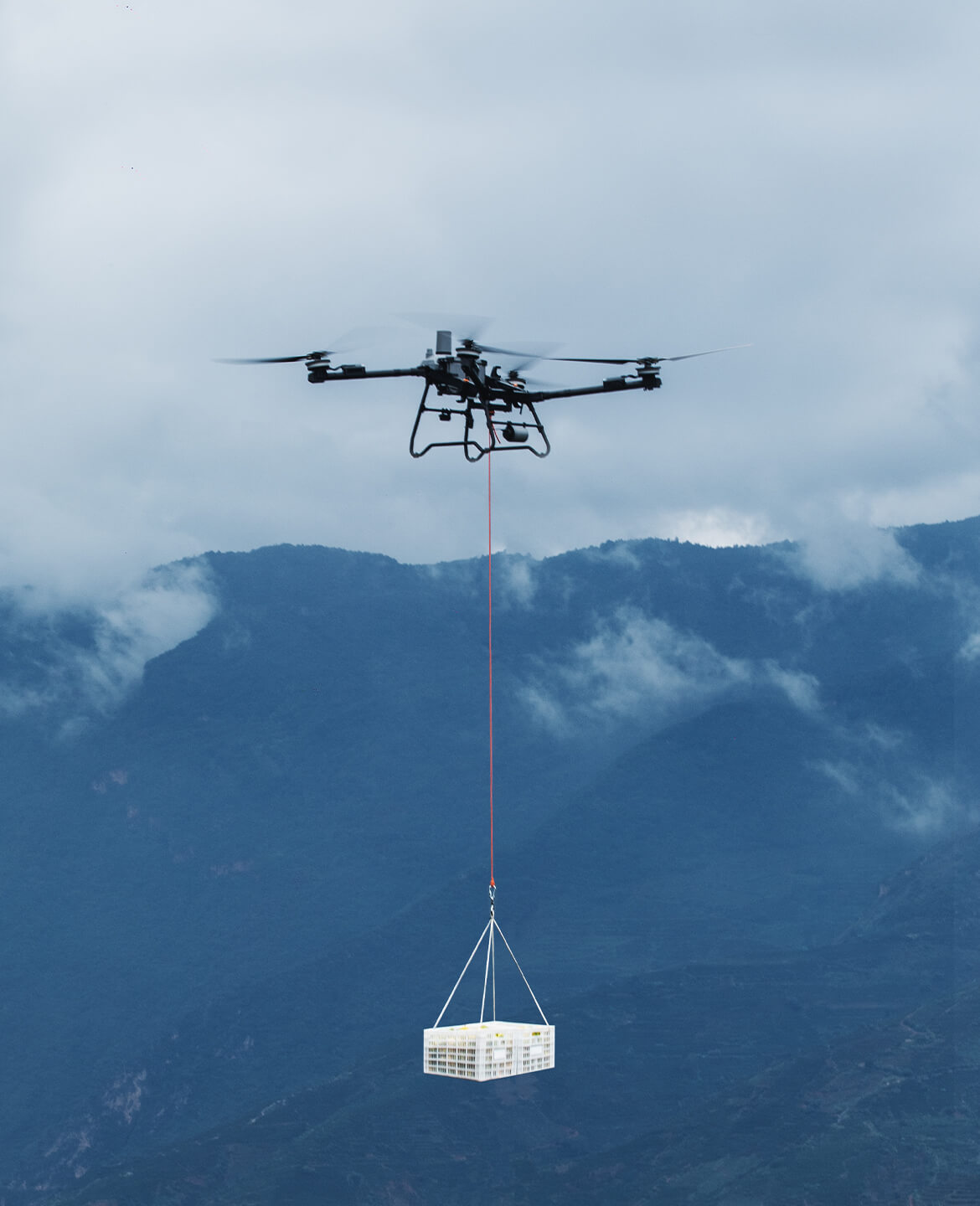 DJI Agras T70P elevando cesta sobre montañas
